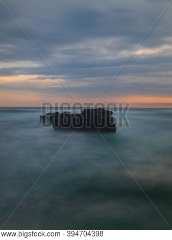 Picturesque Seascape. Amazing Landscape. Rock In The Ocean. Motion Waves. Silky Water. Long Exposure