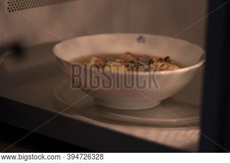 A Bowl Of Soup Is Going To Be Heated In A Microwave Oven