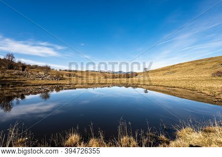 Small Lake For Cows In Lessinia Plateau Regional Natural Park, In The Background The Monte Baldo (ba