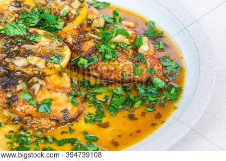 Chicken Francese - Fried Chicken Breast With Lemon Slices And Delicious Sauce On A White Plate Close