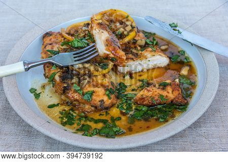 Chicken Francese - Fried Chicken Breast With Lemon Slices And Delicious Sauce On A White Plate Close