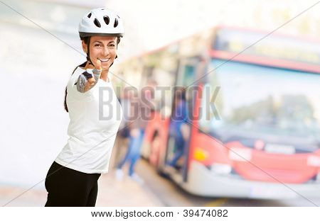 Femme portant casque montrant le pouce vers le haut, en plein air