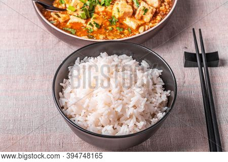 Traditional Chinese Sichuan Cuisine - A Bowl Of Rice And Mapo Tofu In A Large Plate On A Rustic Tabl