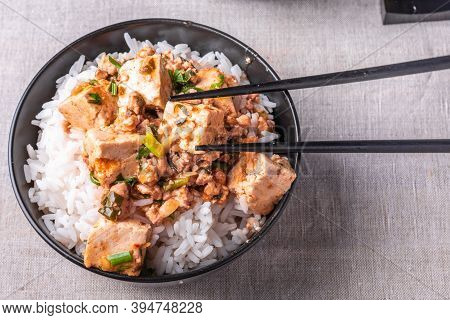 Traditional Chinese Sichuan Cuisine - A Bowl Of Rice With Mapo Tofu On A Rustic Background