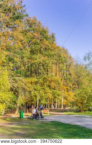 Borger, Netherlands - November 08, 2020: People Enjoying The Autumn Sun On A Bench In Borger, Nether