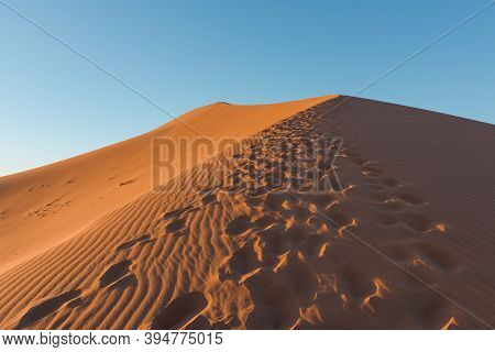 Wide Angle Shoot Of Footpath In Desert Dunes Of Erg Chigaga.sahara, At Sunrise. Morocco. Concept Of