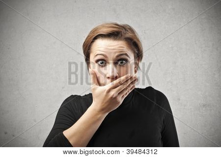 Donna stupita che copre la bocca con la mano destra