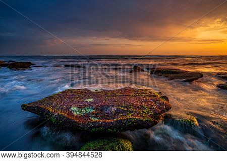 Beautiful Seascape. Beach With Rocks And Stones. Low Tide. Big Flat Stone Covered By Seaweeds. Motio