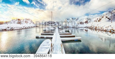 Charming Winter Scenery With Yachts And Boats Nier Pier In Small Fishing Village And Snowy  Mountain