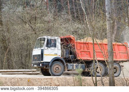 Grodno, Belarus - April 2020: Heavy Laden Multi-ton Truck Maz With White Cab And Orange Body Rides A