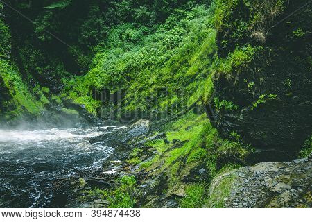 Scenic Rivers Flowing In Hills Overgrown With Green Grass