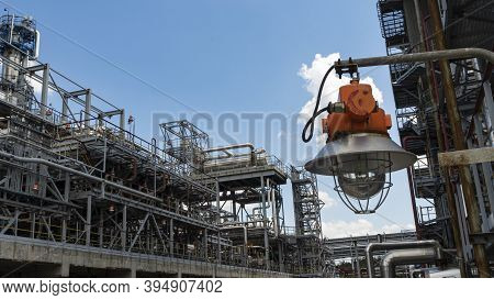 Industrial Explosion Proof Lantern On The Background Of The Refinery Plant And Classic Blue Sky.