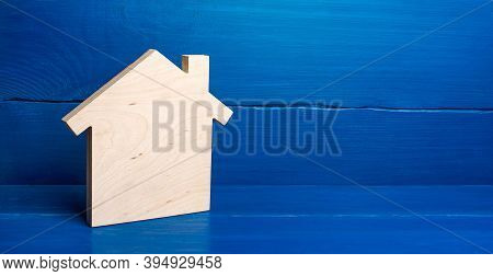 Wooden Plane In Shape Of House Figurine On A Blue Background. Minimalism. Real Estate Concept. Buyin