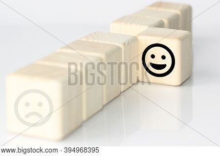 Close Up Custome Choose Smiley Face And Blurred Sad Face Icon On Wood Cube, Service Rating, Satisfac