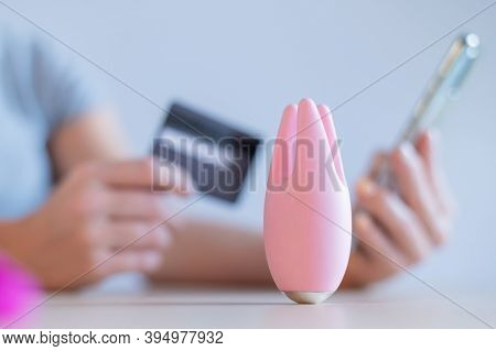 Faceless Woman Holding A Credit Card Smartphone. Clitoral Vibrator On The Table. Online Sex Shop Con