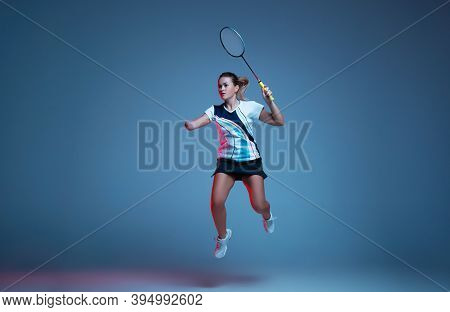 In Jump. Beautiful Handicap Woman Practicing In Badminton Isolated On Blue Background In Neon Light.