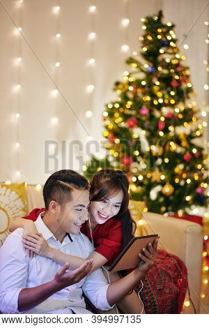 Hugging Young Vietnamese Couple Video Calling Friends Or Relatives On Christmas Eve