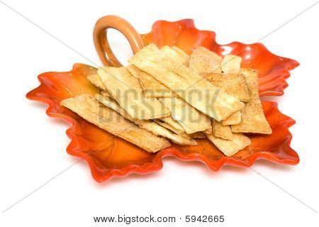 Khvorost mit Zucker auf einer Platte in Form von Herbst leaf