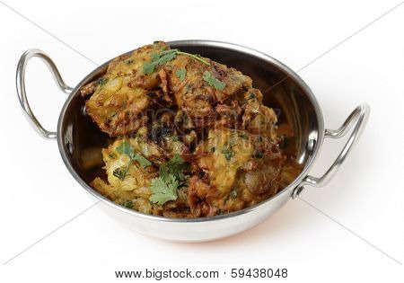Homemade onion bhajis, an Indian appetiser, served in a kadai or karahi wok.