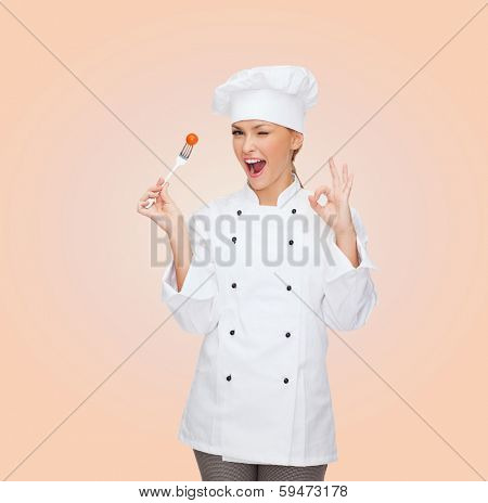 cooking and food concept - smiling female chef, cook or baker with fork and tomato showing ok sign