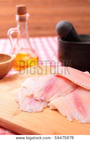 Raw fish tilapia on cutting board and spices