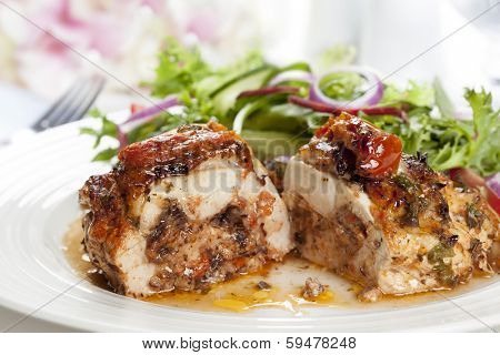 Stuffed chicken breast with salad.  Sundried tomato and mozzarella filling.