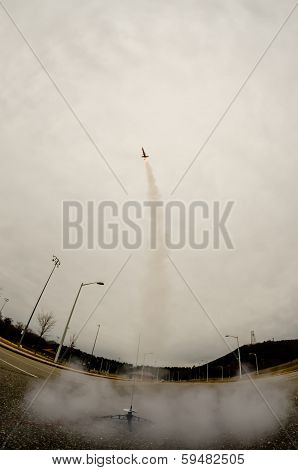 model rocket launch in parking lot on cloudy day