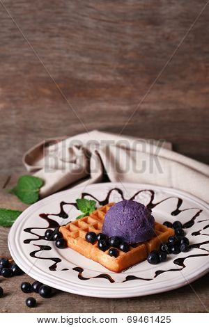 Tasty belgian waffles with ice cream on wooden table