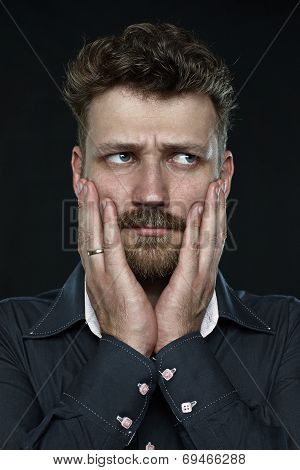 Worried married handsome bearded man anxiously press his palm to face  close up portrait