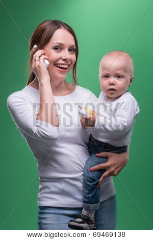 Mother holding toddler son with toy phone