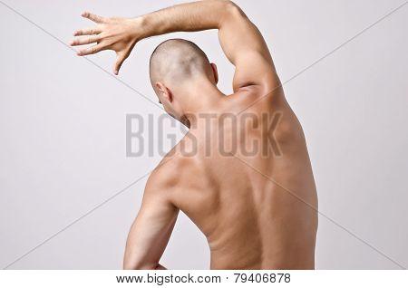 Topless man posing with his back.