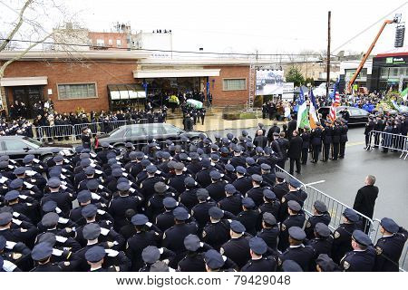 NYPD officers salute flag-draped coffin