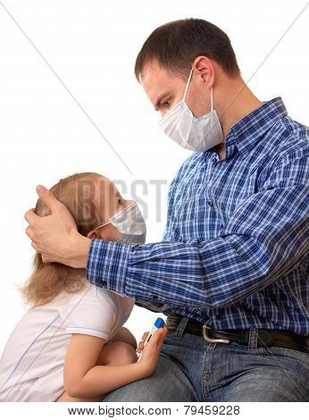 Family in medical masks with a thermometer.