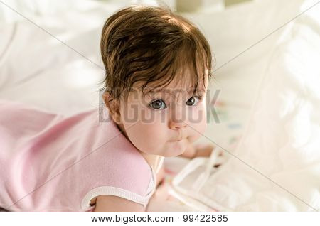 Cute Sweet Little Baby Girl Looking At Camera And Lying On Bed