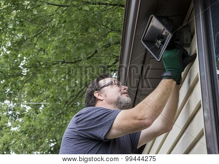 Electrician Taking Down Exterior Light