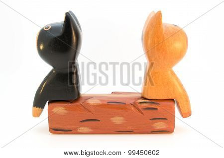 Two wooden cats back to back