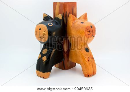 Two wooden cats lean on stem
