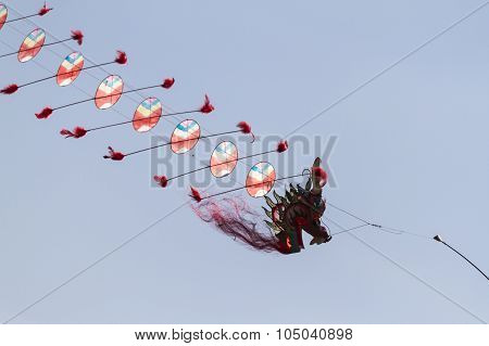 Colorful Kites Flying  In Single File In The Sky