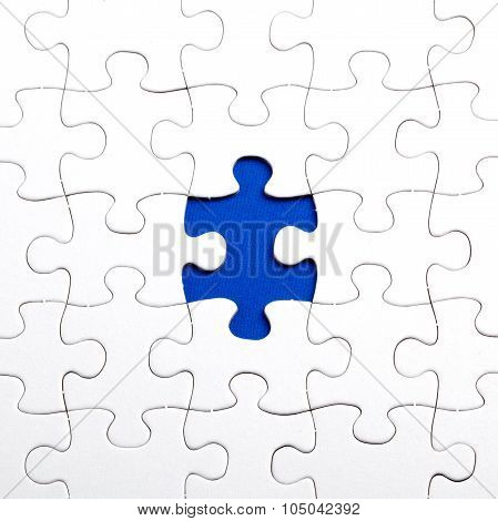 Plain white jigsaw puzzle on Blue background autism awerness symbol