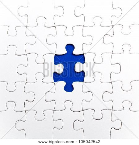 Plain white jigsaw puzzle on Blue background autism awerness symbol