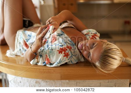 Young Sexy Woman Laying On The Bar Typing On Mobile Phone