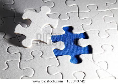 Plain white jigsaw puzzle on Blue background autism awerness symbol