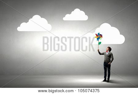 Young happy guy in casual with colorful windmill in hand