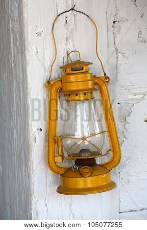 Old dusty oil lamp on wooden wall