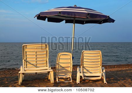 Drei Liegestühle am Strand