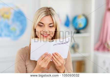 Nice girl reading dictionary
