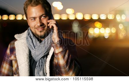 Handsome Young Man Speaking On Smart Phone At Autumn Sunset In City