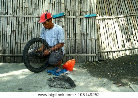 motorcycle mechanic fixing a motorcycle's tire