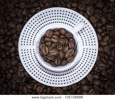 Cup Polka Dots Standing On Coffee Beans. Blur, Top View, Focus On Beans In Mug