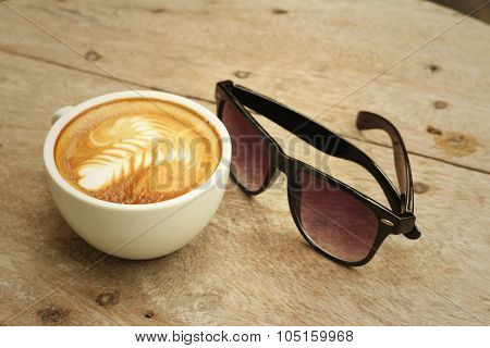Coffee With Sunglasses On Background Of Wooden.